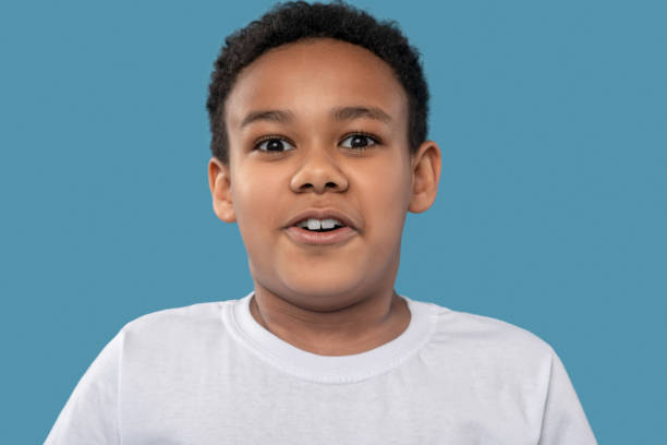 istock Surprised delighted african american boy on blue background 1327680049