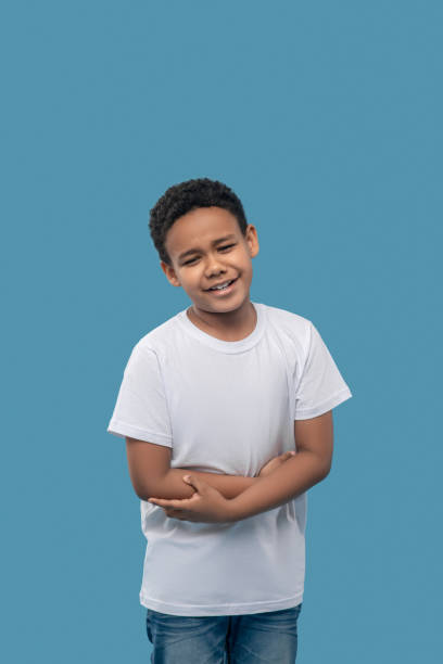 istock Sad dark skinned boy holding stomach with hands 1327680059