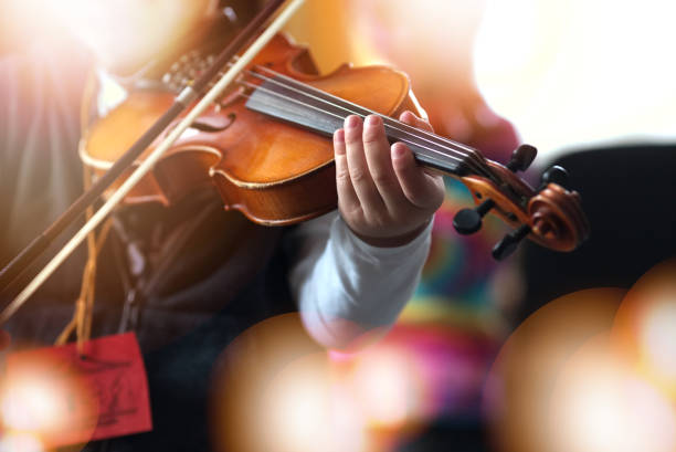 Child playing the violin in  room