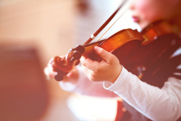 istock Child playing the violin in  room 1327680591