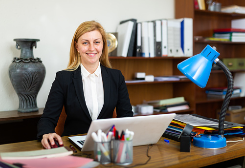 Portrait of female office worker in company at a modern workplace