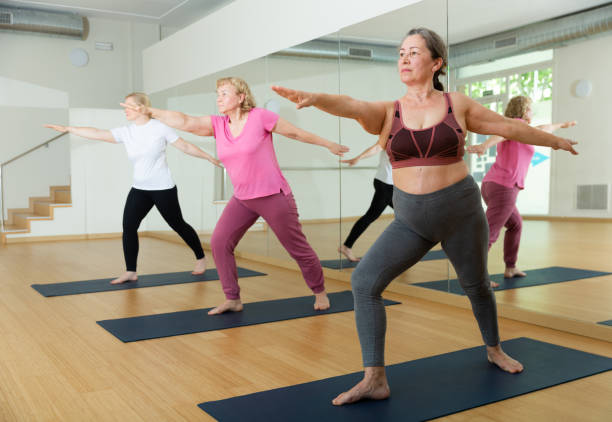 istock Group of active mature women practicing yoga 1327683390