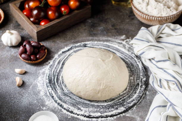 istock Pizza dough on rustic background. Cooking time. Ingredients for making dough. 1327683514