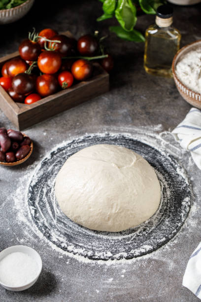 istock Pizza dough on rustic background. Cooking time. Ingredients for making dough. 1327683552