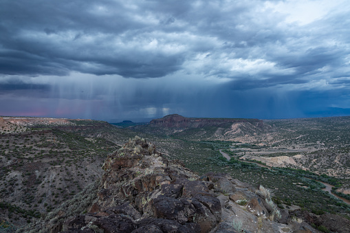 Dramatic evening thunderstorm approaching over the Rio Grande river canyon near White Rock, New Mexico.