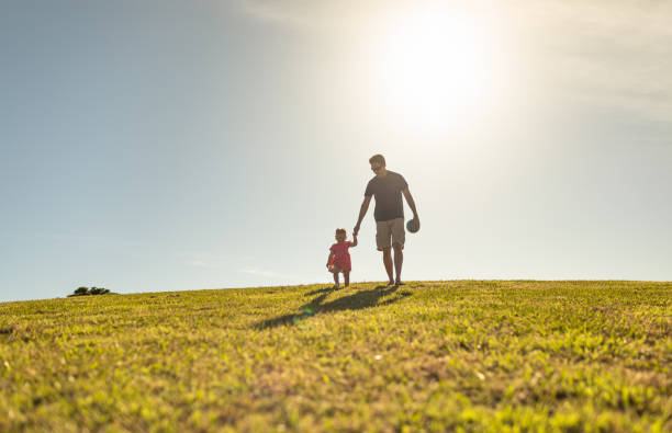 istock Father and daughter walking in the park. 1327685688
