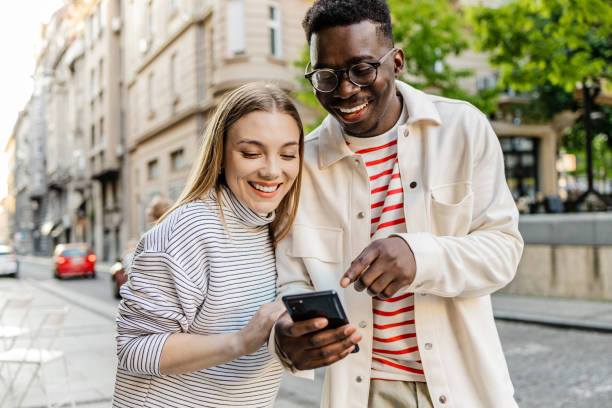 istock Friends walking and using mobile phone on the move 1327686563