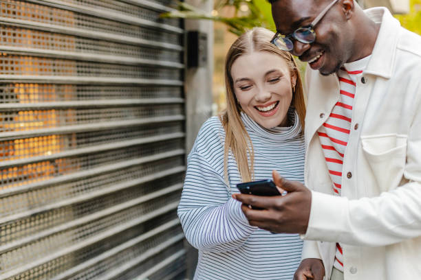 istock Friends walking and using mobile phone on the move 1327686598