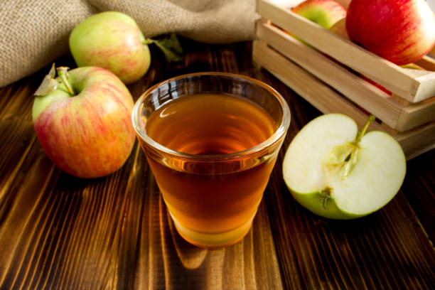 apfelsaft im trinkglas auf dem braunen holzhintergrund - burlap fruit apple freshness stock-fotos und bilder