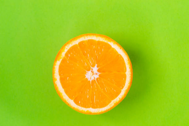 istock Top view of one orange round fruit on bright green background. Rich citrus texture. Copy space 1327687914
