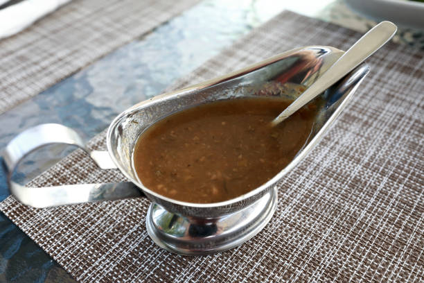 Tkemali sauce in gravy boat on table in restaurant