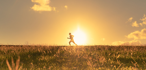 Male athlete running at sunset. Healthy lifestyle concept.