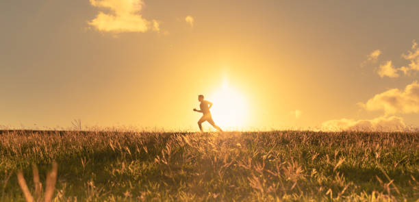 mężczyzna biegnący o zachodzie słońca. - sun people jogging sunset zdjęcia i obrazy z banku zdjęć