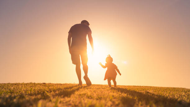 istock Father and daughter walking in the park 1327688333
