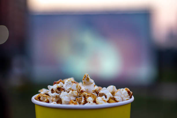 istock A glass of caramel popcorn on a blurry screen background. 1327688609