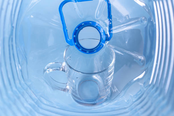 istock View from inside an empty plastic bottle against the background of an empty glass glass. 1327688678