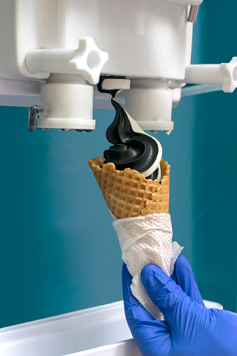 Preparation of ice cream from the machine. Frozen two kinds of black and white.