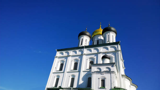 istock Trinity Cathedral, Pskov, Russia. Blue sky background. Pskov Kremlin. Ancient fortress. Golden dome. Famous place. Travelling. Russian tourist attractions. Architecture. Travel destination. White wall 1327692334