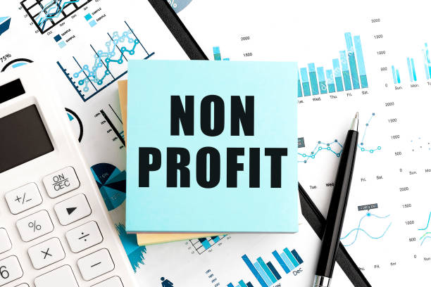 istock Text NON PROFIT on stickers. Pen and calculator on clipboard with charts, documents and graphs. Business concept. Top view. 1327693617