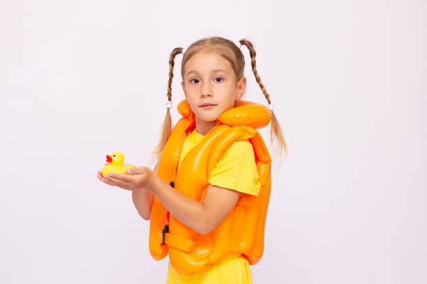 young girl with yellow life-jacket and a rubber duck on a white background. - life jacket isolated red safety imagens e fotografias de stock