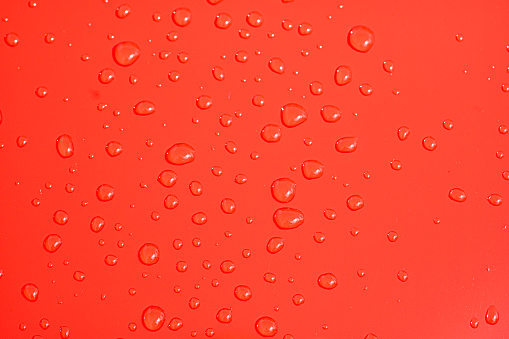 Water drops on a red car bonnet
