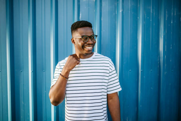 istock Young, cheerful black man on blue door background 1327702526