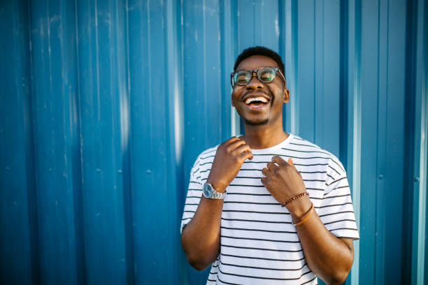 Young, cheerful black man on blue door background