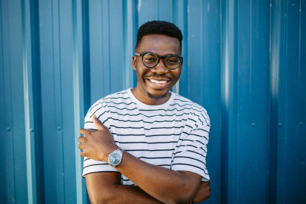istock Young, cheerful black man on blue door background 1327702553
