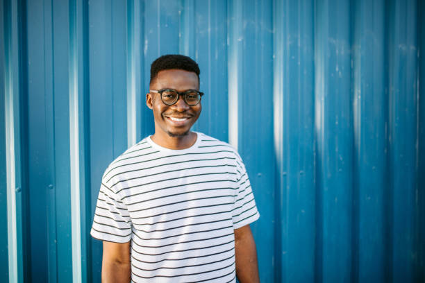 istock Young, cheerful black man on blue door background 1327702558