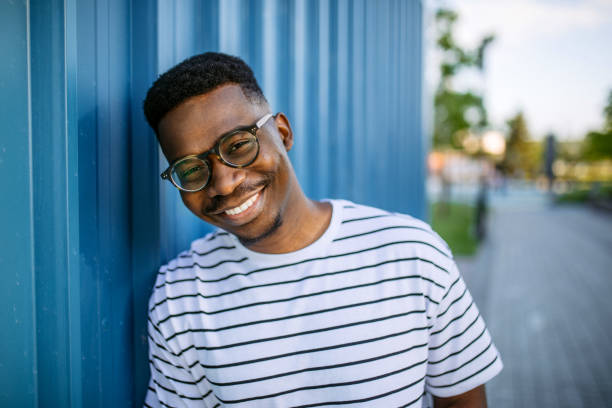 Young, cheerful black man on blue door background