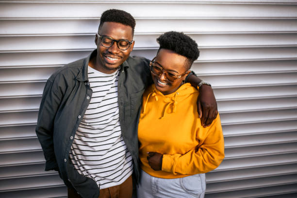 istock Cheerful, smiling black couple leaning on grey garage door 1327702592