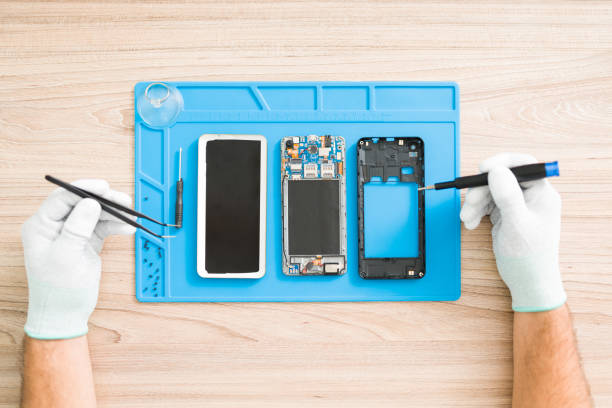 istock Young man fixing a smartphone with tweezers 1327703304