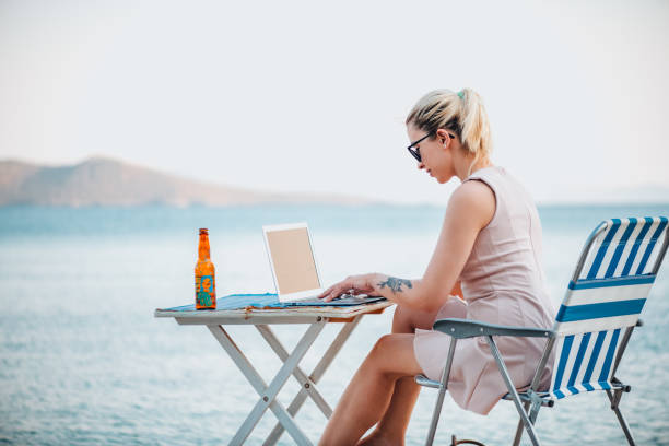 istock Freelance Woman Working With Laptop on the Beach 1327705972
