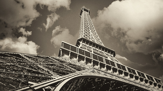 Eiffel Tower and typical residential buildings in the foreground. Eiffel Tower is one of the most iconic landmarks in Paris. Vintage photo stylization. Sepia toning