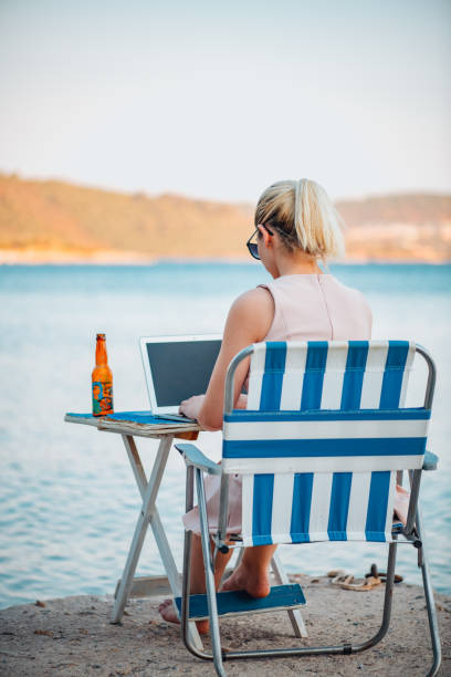 istock Freelance Woman Working With Laptop on the Beach 1327709807