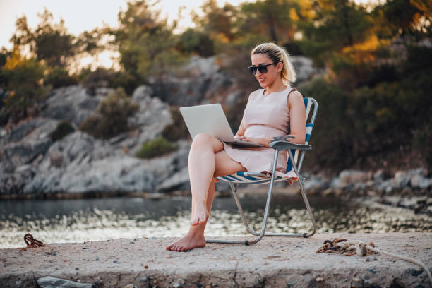 istock Freelance Woman Working With Laptop on the Beach 1327711063