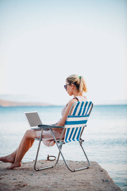 istock Freelance Woman Working With Laptop on the Beach 1327711096