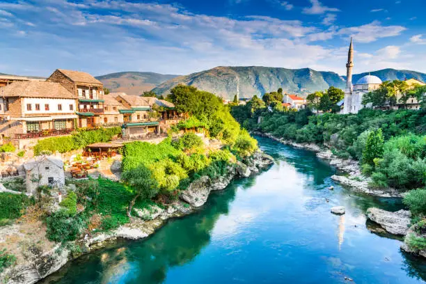 Mostar, Bosnia and Herzegovina. Morning sun on Nerteva River and Old City of Mostar, with Ottoman Mosque