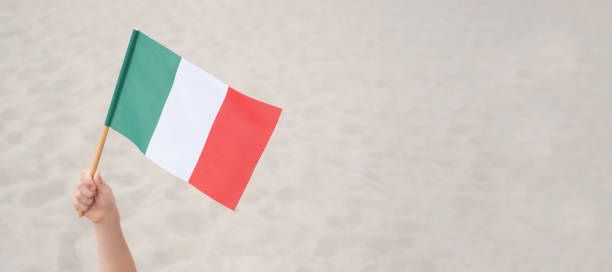 istock Child's hand waving Italian flag. 1327716282