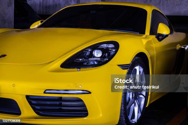 Closeup Of Car Headlights And Car Wheel Of Yellow Porsche Sports Car Parked In The Parking Lot Stock Photo - Download Image Now