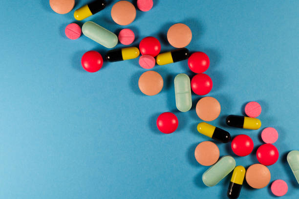 pills and capsules diagonal line on blue flat-lay - vibrant color healthcare and medicine healthy lifestyle vitamin pill imagens e fotografias de stock
