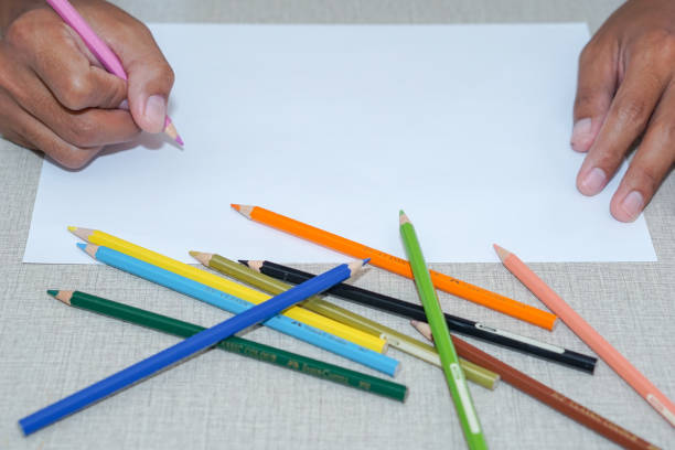 istock man's hand drawing on blank white paper with color pencil on work desk 1327739801