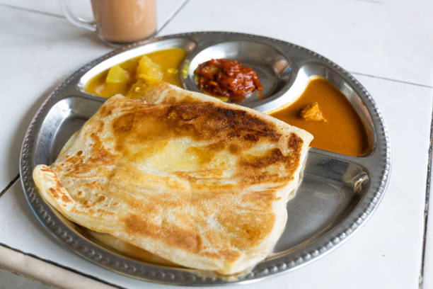 Roti planta is popular breakfast in Malaysia. It is roti canai with added margarine. Roti planta is popular breakfast in Malaysia. It is roti canai with added margarine accompanied with curry and dhal. roti canai stock pictures, royalty-free photos & images