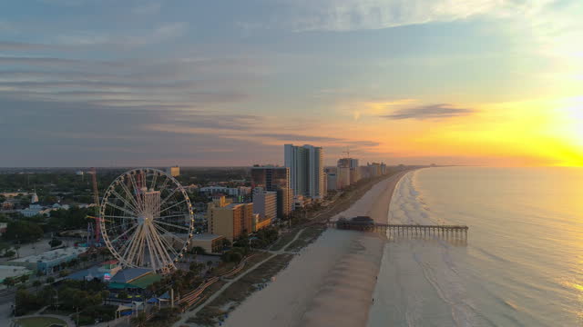 Sunrise on the Myrtle Beach, South Carolina. Aerial scenic view along the shore toward the Downtown and amusement park.