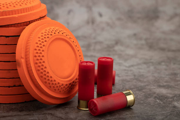 Clay disc flying targets and shotgun shells on texture background ,Clay Pigeon target game