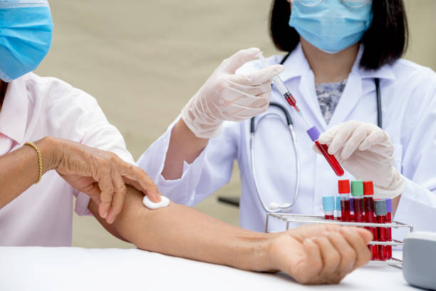 a doctor hands with a syringe and a sample of blood tube for analysis and test virus disease in the laboratory from elderly patients, this research is plasma biomedicine for diagnostic medical healthcare - healthcare and medicine laboratory senior adult analyzing imagens e fotografias de stock