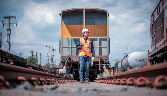 Engineer under inspection and checking construction process railway switch and checking work on railroad station .Engineer wearing safety uniform and safety helmet in work.