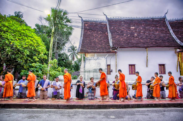 ストリートモーニング、ルアンパバーン、ラオスで観光客から食べ物を提供する僧侶のグループ - ルアンパバン ストックフォトと画像