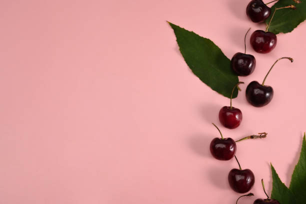 istock Fresh cherries with stalks on pink background. Copy space. 1327748814