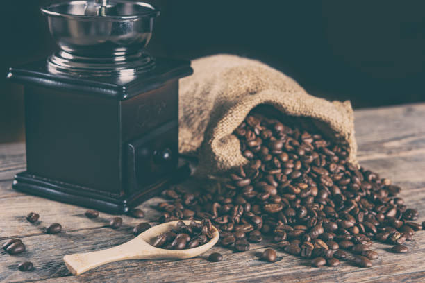 istock Coffee beans and retro manual coffee grinder on wooden table 1327752179